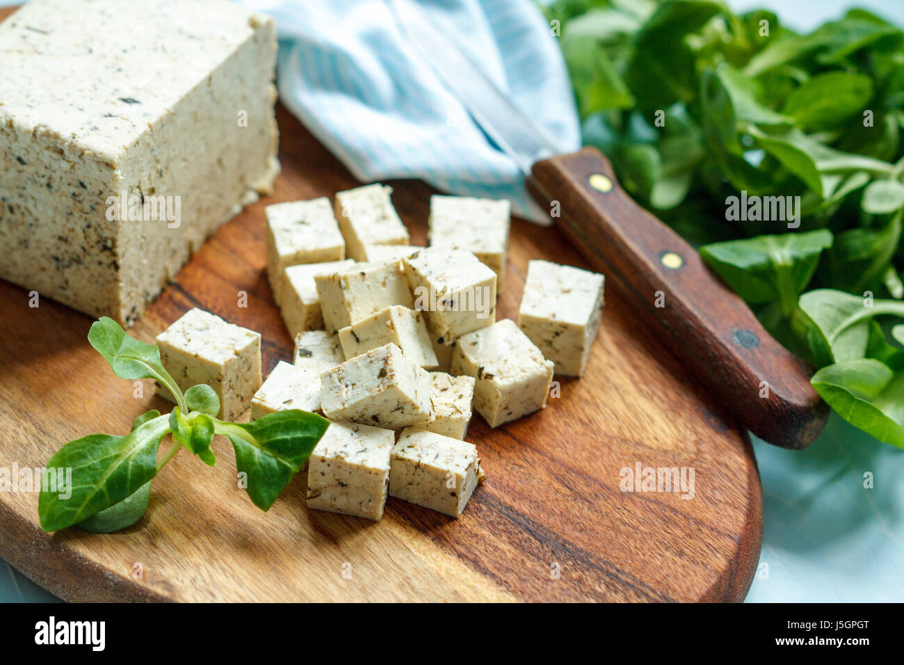 Tofu in Scheiben geschnitten auf einem Holzbrett. Liebe für eine gesunde vegane Ernährung Konzept Stockfoto