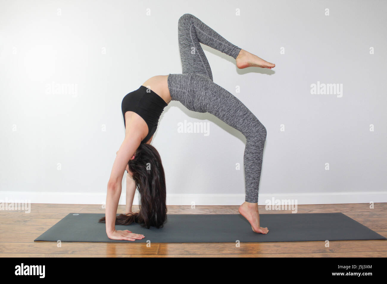 Schöne Frau dabei eine Yoga-Pose genannt Rad Pose Variation. Stockfoto