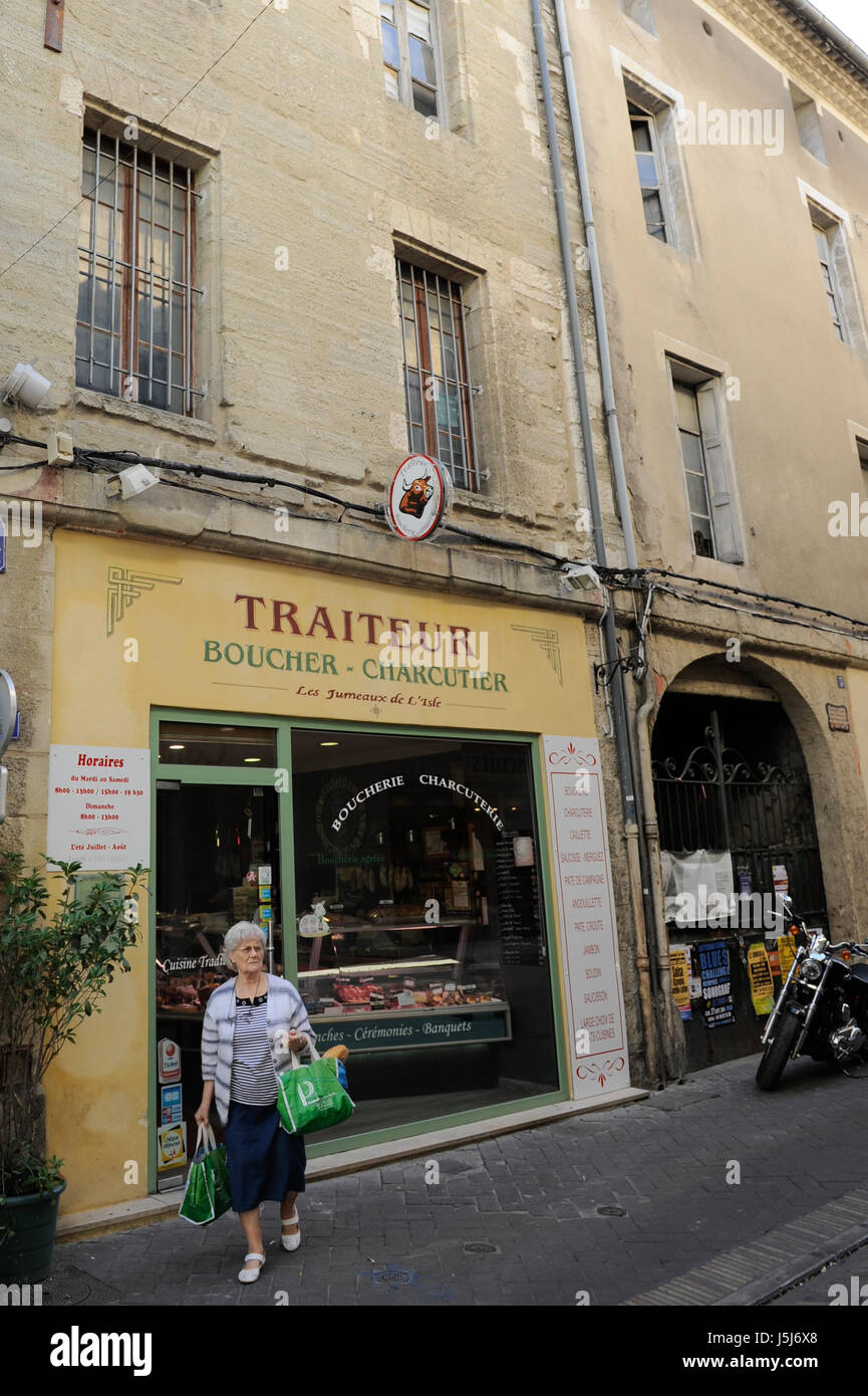Eine Französin, die Einkaufen in einer Boucher und Wurstwaren (Metzgerei und Feinkost) in L'Isle-Sur-la-Sorgue, Frankreich Stockfoto