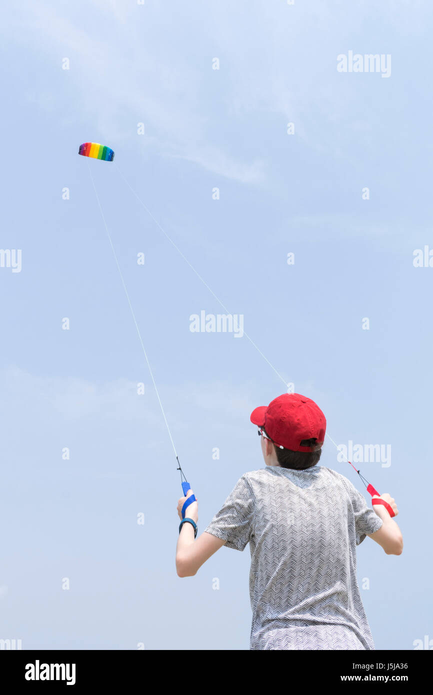 Teenager in roten Hut einen bunten Drachen fliegen. Mit Textfreiraum Stockfoto
