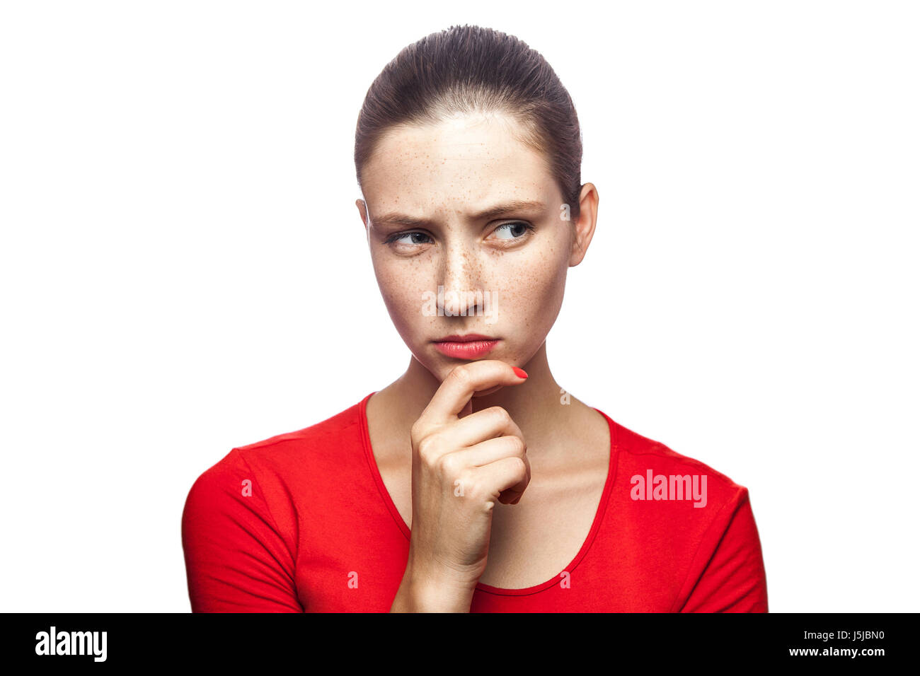 Porträt von nachdenklich ernst Frau im roten T-shirt mit Sommersprossen, Studio gedreht. isoliert auf weißem Hintergrund. Stockfoto