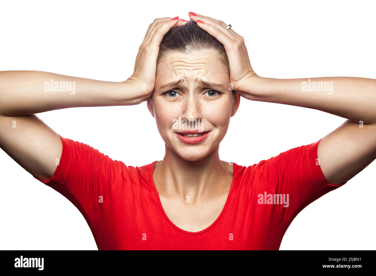 Porträt der traurige unglückliche Frau im roten T-shirt mit Sommersprossen. Studio gedreht. isoliert auf weißem Hintergrund. Stockfoto