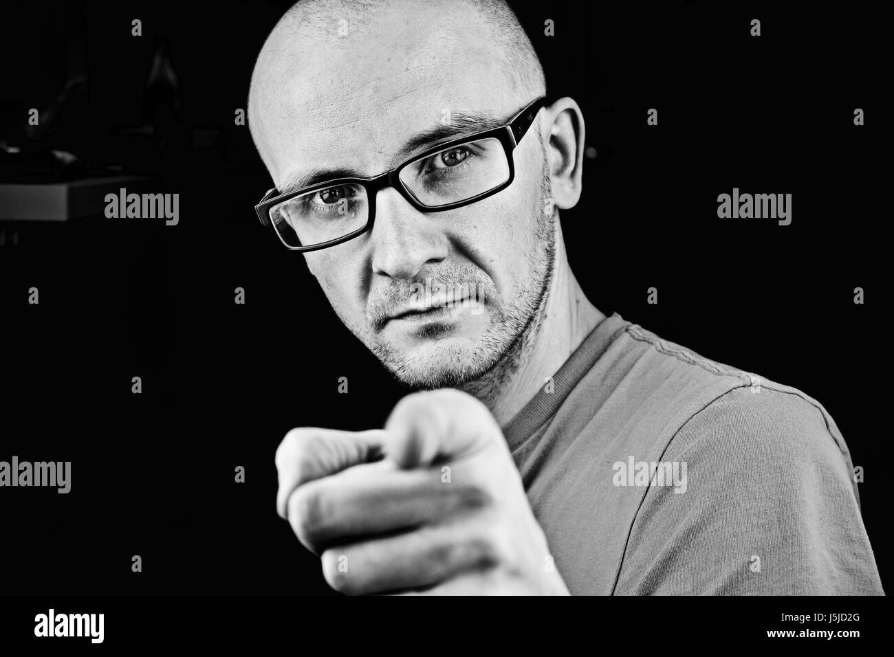 Junger Mann in Gläsern zeige finger Stockfoto