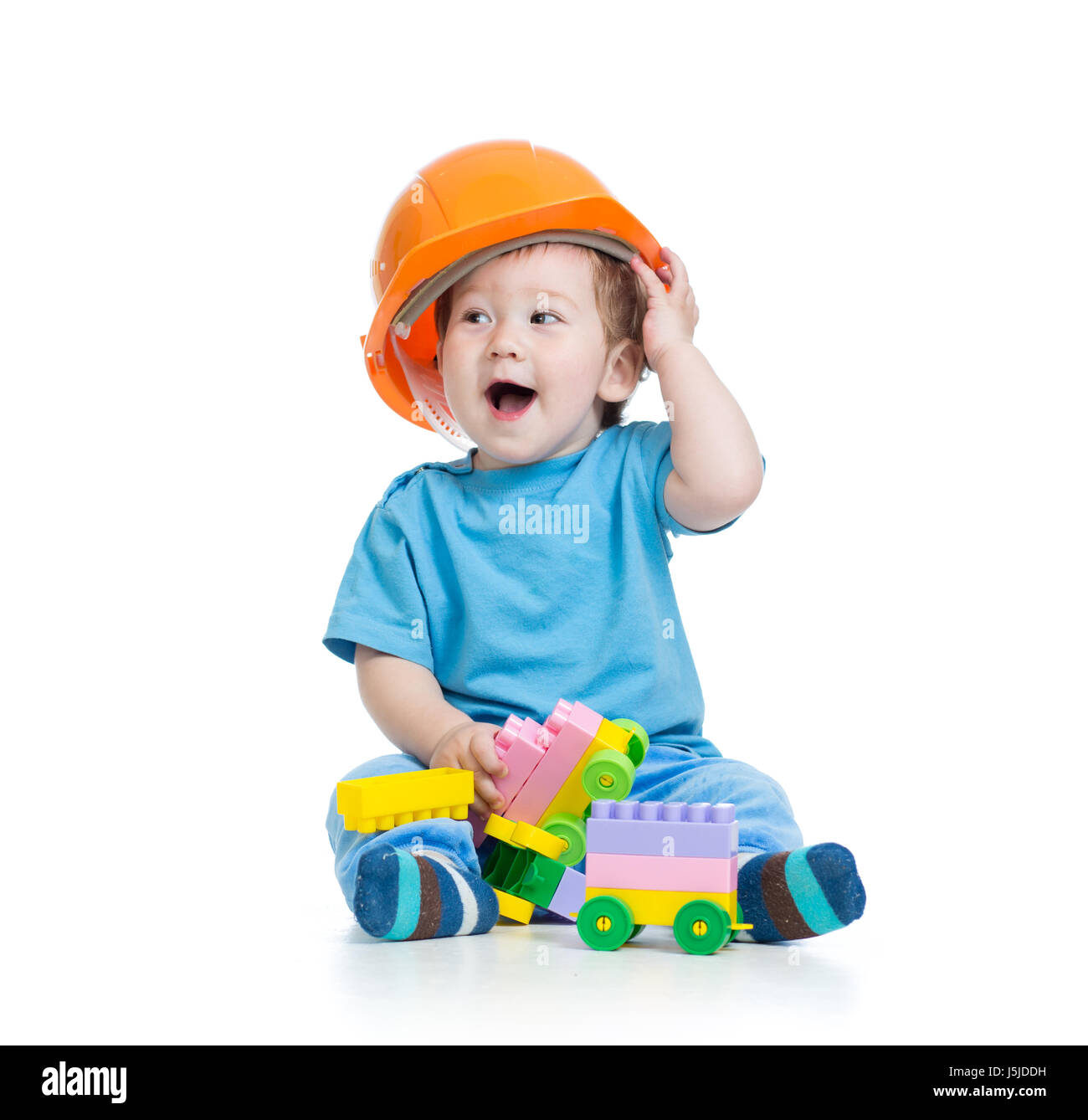Kleinkind Kind in Bauarbeiterhelm spielt mit Klötzchen auf weißem Hintergrund Stockfoto