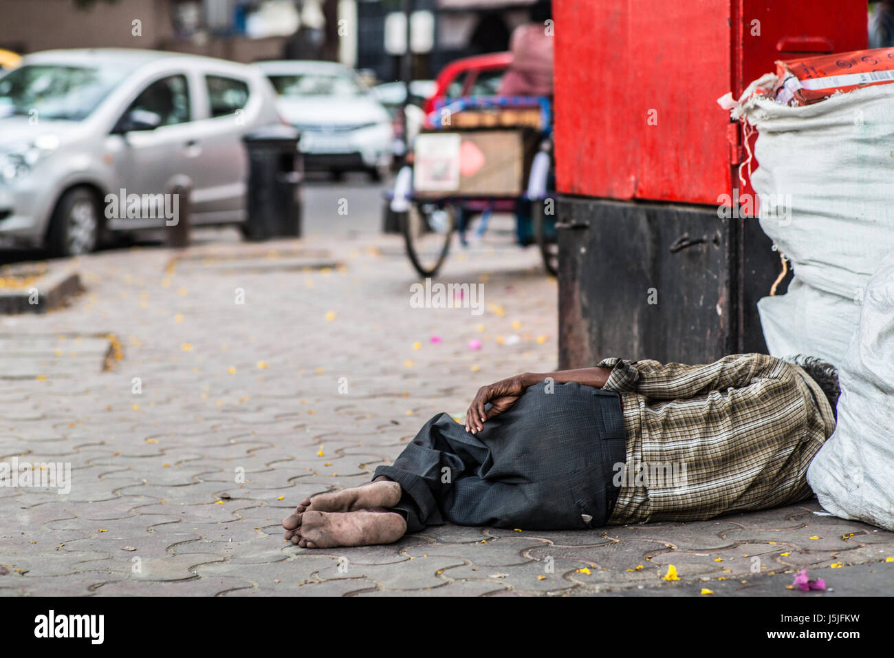 Ein Obdachloser schläft in einer Ecke auf einer Straße in Mumbai, Indien. Stockfoto