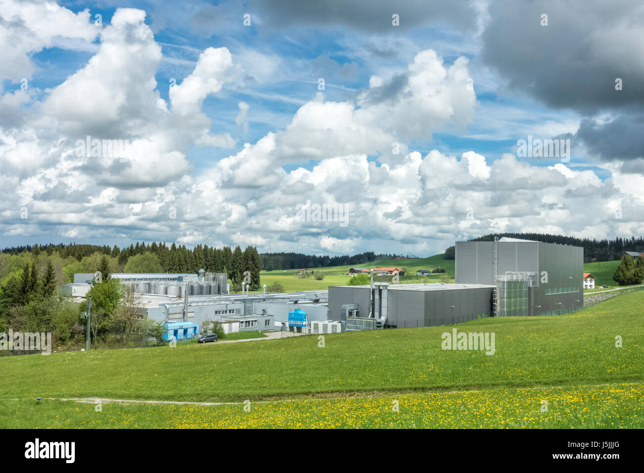 Industrielle Anlage in einer ländlichen Landschaft und Blumenwiese Stockfoto