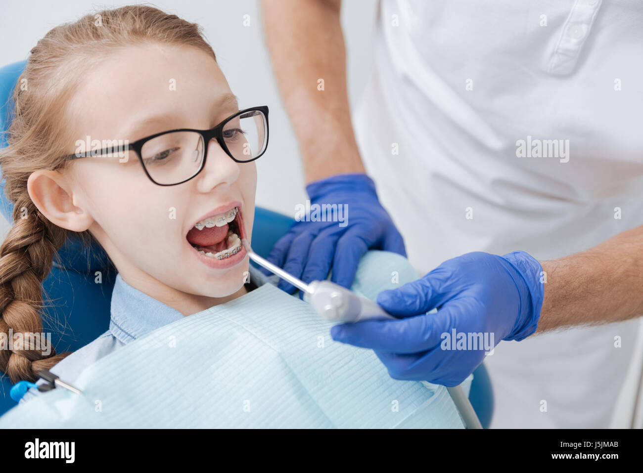 Lebendiges Ingwer Mädchen beschäftigt Dentalgeräte für Verfahren Stockfoto