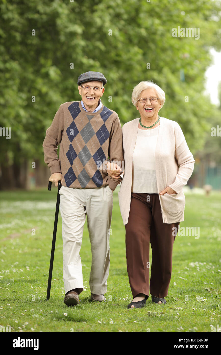 In voller Länge Portrait von ein glückliches Reife paar zu Fuß in Richtung der Kamera in einem park Stockfoto
