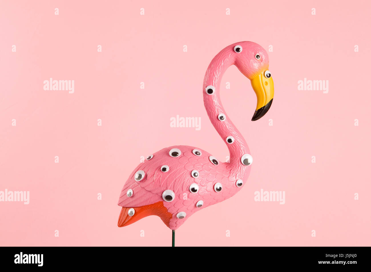 skurrile und Freak rosa Kunststoff Flamingo auf einem rosa Hintergrund mit zahlreichen Augen Farbverlauf und Töne auf Töne Stockfoto