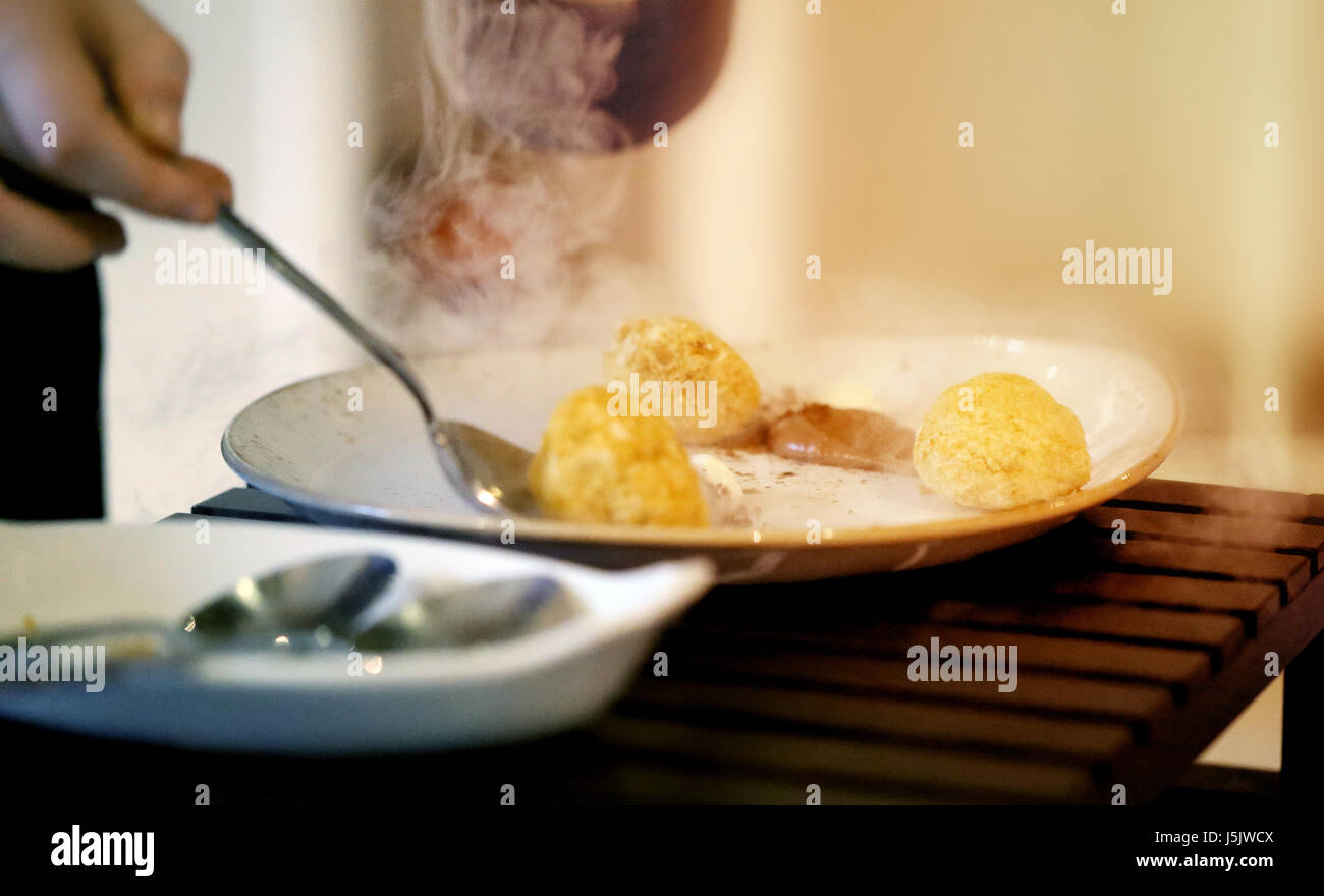 Käsekuchen auf dem Teller mit Schokolade gekocht in flüssigem Stickstoff. Die molekulare Küche. Stockfoto
