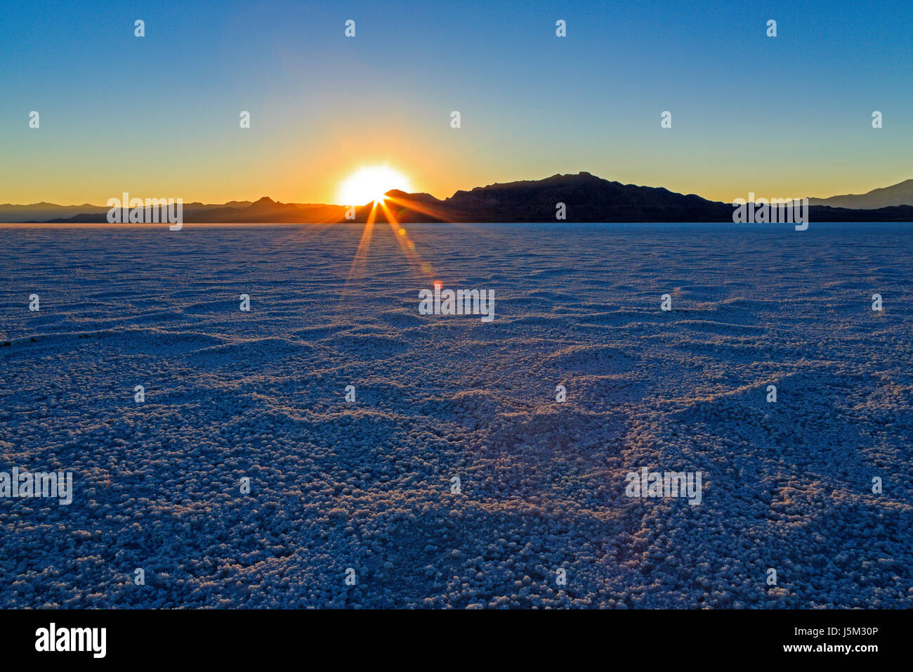 Die letzten Strahlen der untergehenden Sonne leuchtet das körnige Salz auf den Bonneville Salt Flats in der Nähe des Stadt Wendover, Tooele County, northern Utahs, USA. Stockfoto