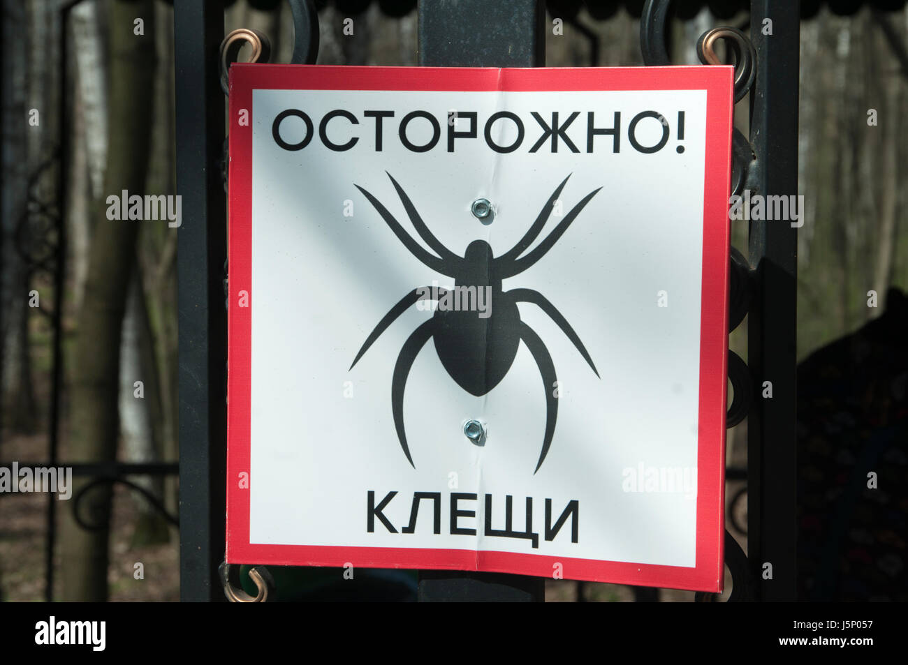 Tablet-"seien Sie vorsichtig von Milben!" in einem Stadtpark Stockfoto
