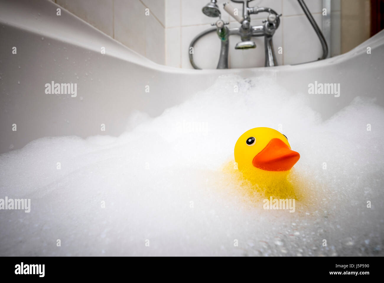 Badewanne, einem Kunststoff Ente in ein Schaumbad. Stockfoto