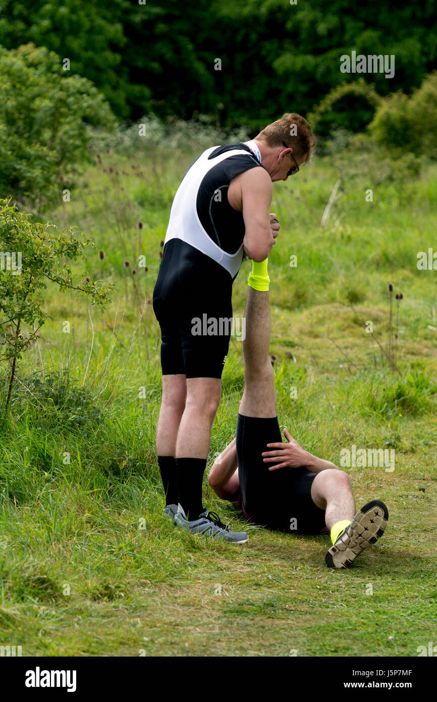 Läufer mit Muskelfaserriss Problem in Stratford Triathlon von anderen Läufer, Bath, UK geholfen Stockfoto