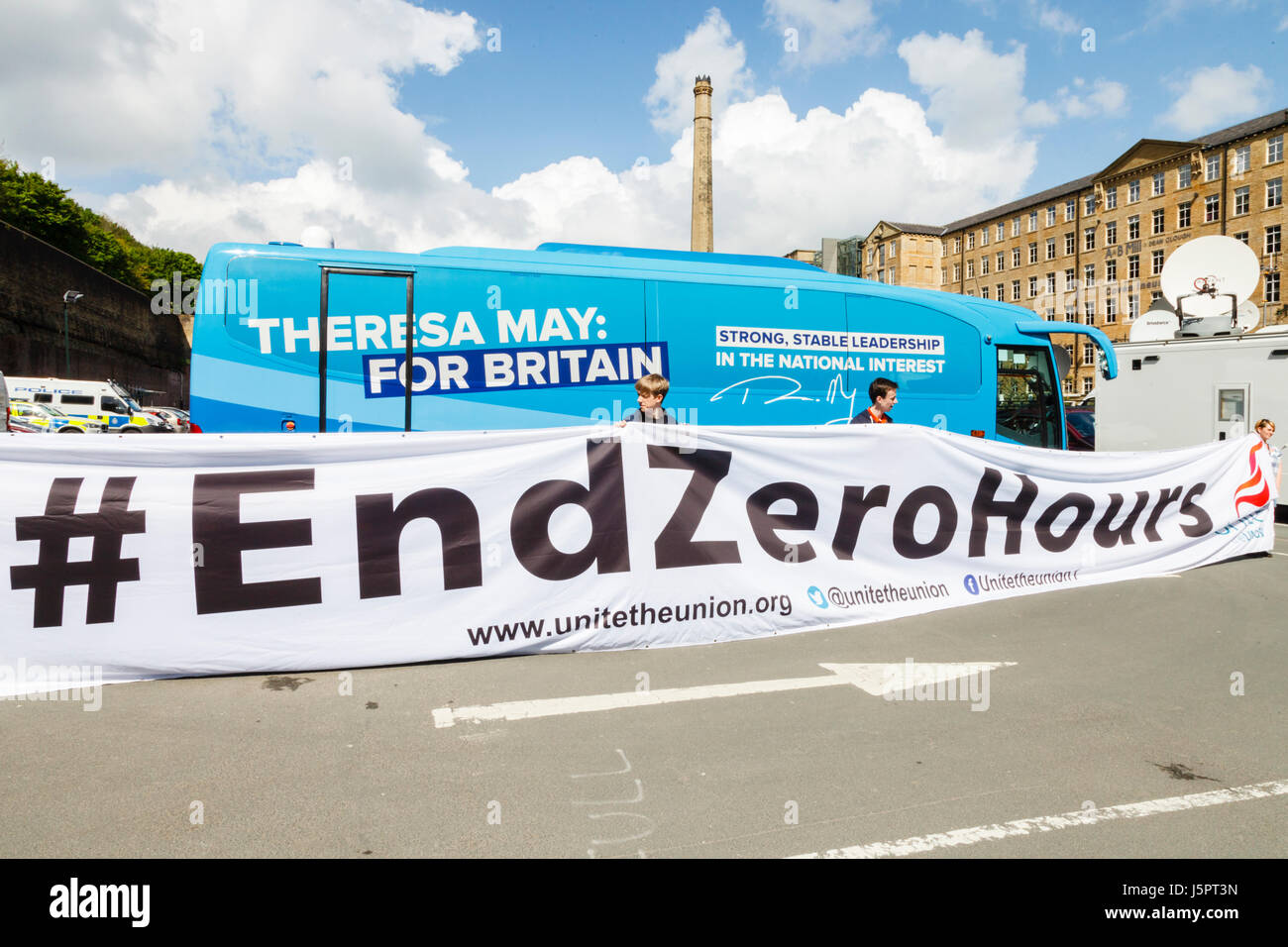 Halifax, UK. 18. Mai 2017. Die Gewerkschaft Unite entfalten eine Fahne neben dem konservativen Wahl Bus in Dean Clough Mills, Halifax. Bildnachweis: Graham Hardy/Alamy Live-Nachrichten Stockfoto