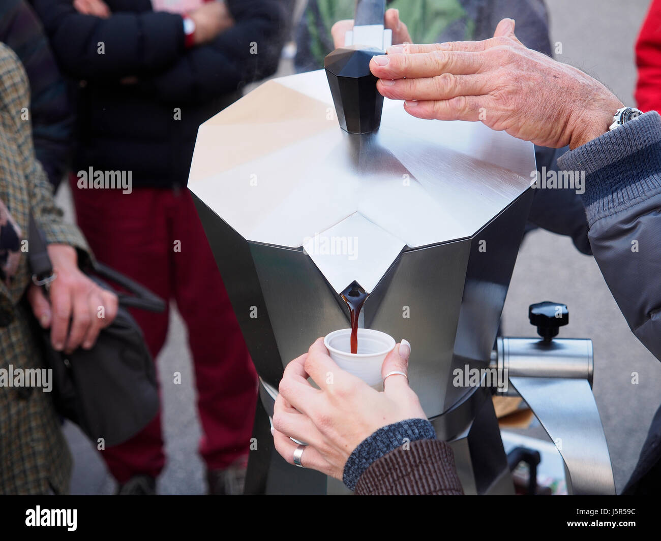 Bieten kostenlosen Kaffee, vorbereitet mit einer riesigen Kaffeekanne, in einer Straße von Triest in einem kalten Morgen Stockfoto