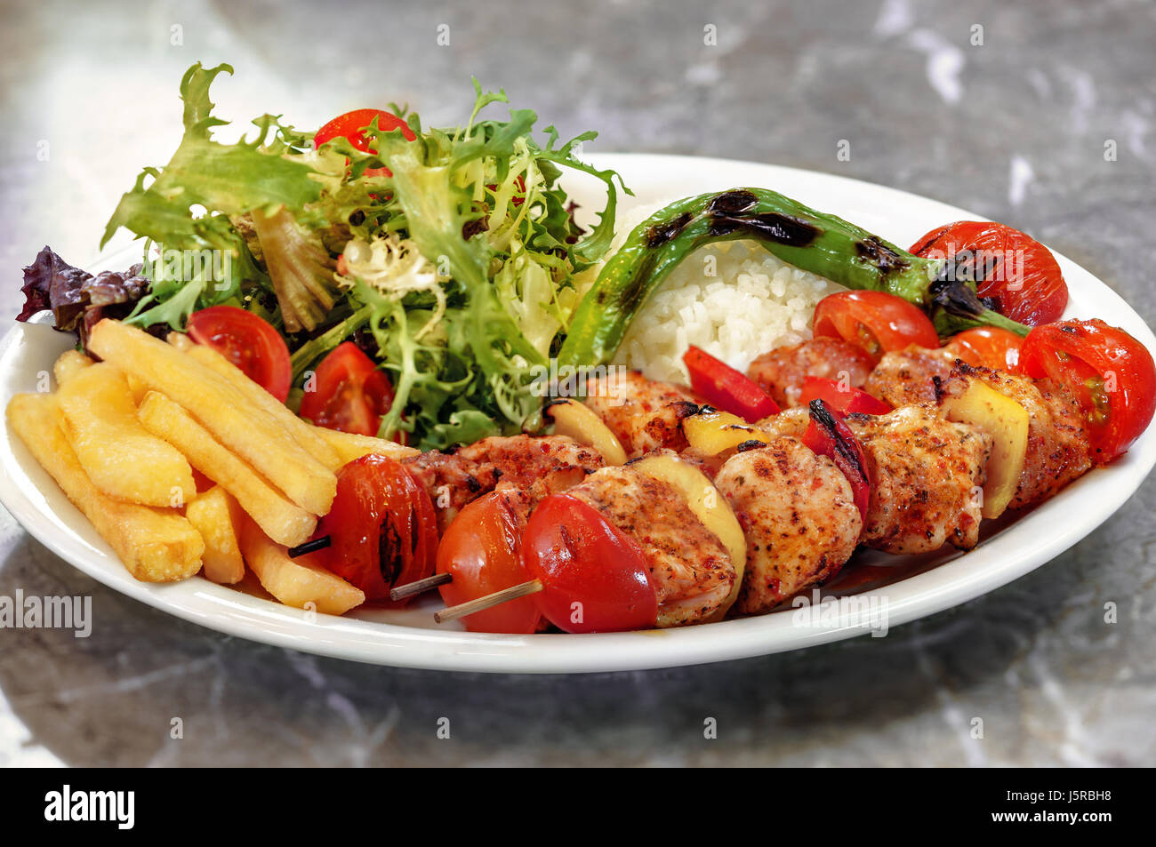 Hähnchen-Spieße, Pommes Frites und Reis mit Blattgemüse Stockfotografie ...