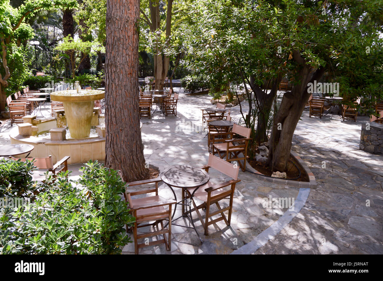 Schattige Terrasse mit Holzstühlen und Tischen für Aperitif zu trinken Stockfoto