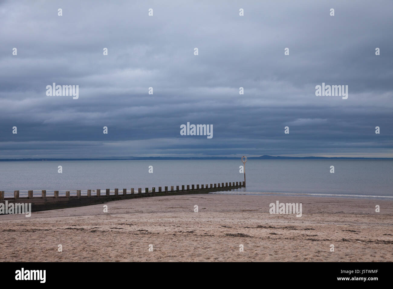 Trübe bewölkten Sonnenuntergang über der alten Mole von Portobello Beach in Edinburgh, die Hauptstadt von Schottland, Großbritannien. Wetter: bedeckt 15. Mai 2017 dunkle blaue Wolke Stockfoto