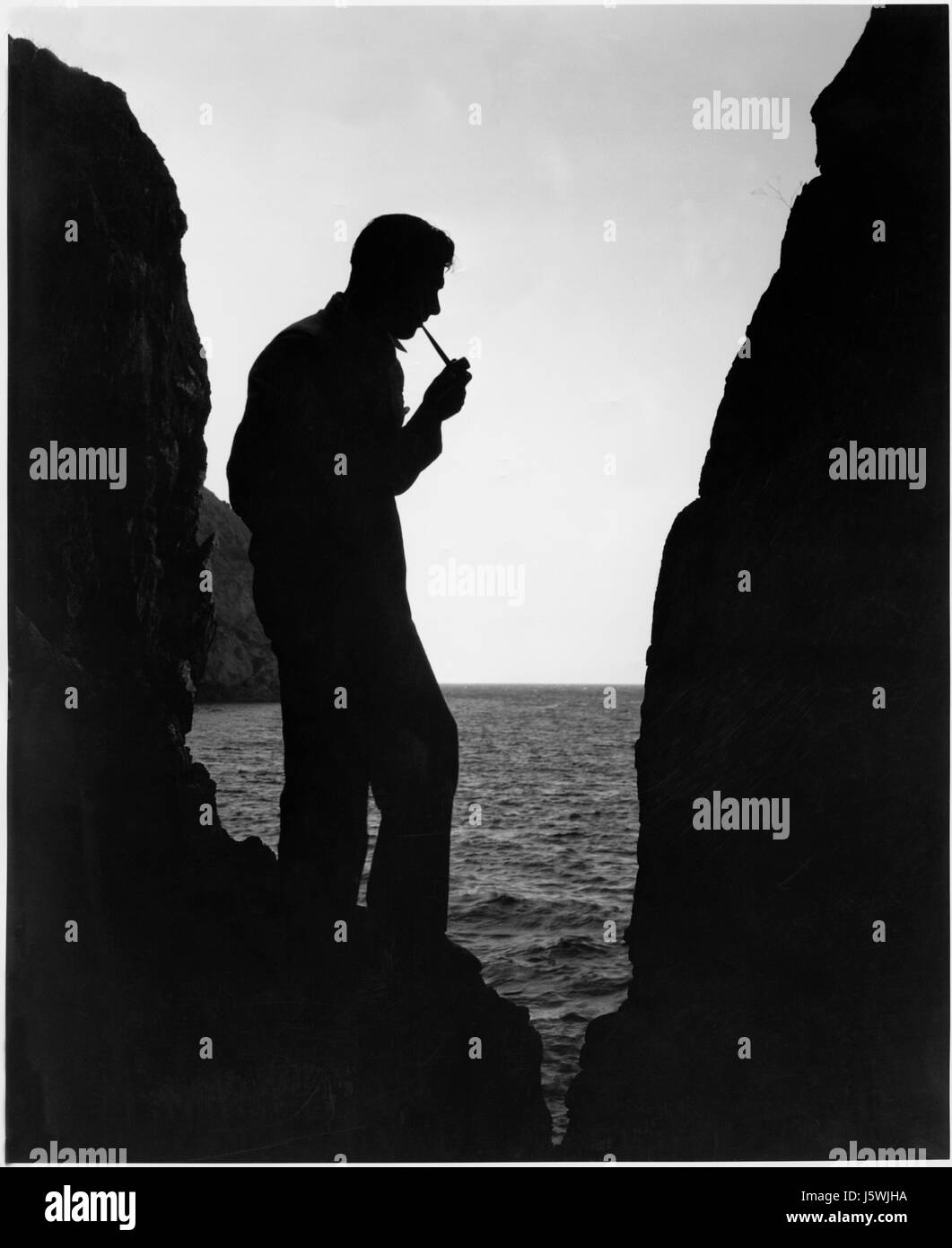 Richard Arlen, Silhouette Portrait Pfeife am Strand, am Set des Films, "Insel der verlorenen Seelen", 1932 Stockfoto