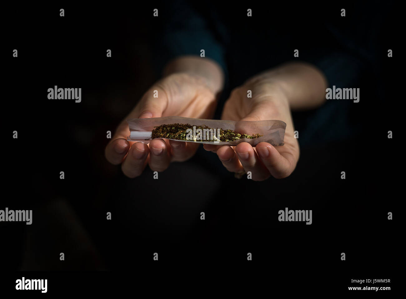 Mädchen Hände Rollen aus einer Mischung von Tabak und Cannabis, die perfekte Gemeinsame Stockfoto