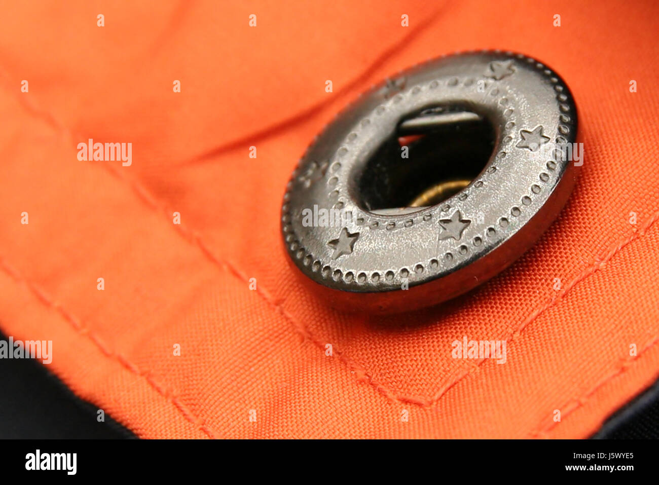 Dichtung Auslöser drücken Sie Taste Knopfloch komplette perfekte Jacke Knopf enger Orange Stockfoto