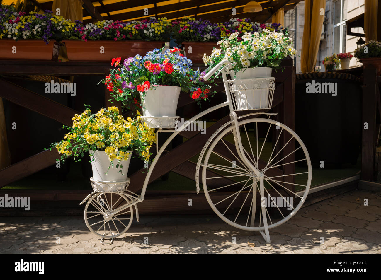 Weiße Fahrräder mit Blumen. Hautnah in einer Straße. Stockfoto