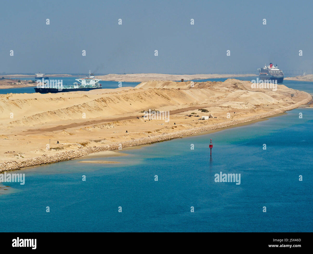 Neuer Abschnitt des Suez-Kanals mit Gegenverkehr, Queen Mary 2 Richtung Norden im rechten Kanal und Öltanker, die Richtung Süden auf der linken Seite. Stockfoto