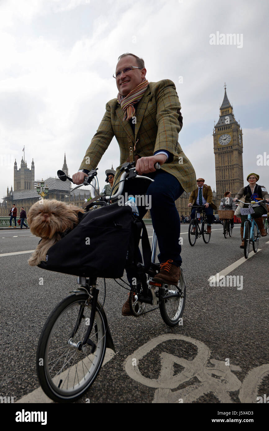 Tweed Run Radfahrer in London überqueren die Westminster Bridge und passieren die Houses of Parliament Stockfoto