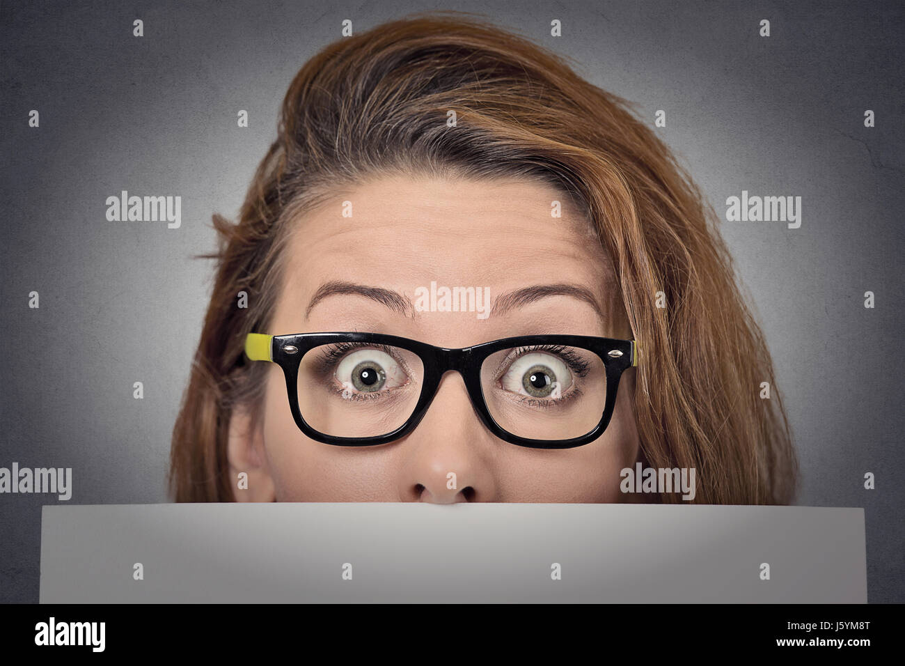 Banner Zeichen Frau spähen über Rand der leeren Blankopapier Plakatwand. Schöne junge Frau mit Brille schauen überrascht und erschrocken lustig mit breiten op Stockfoto