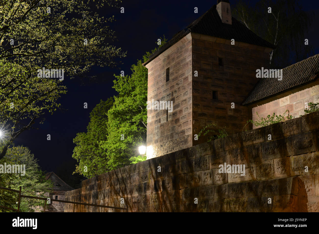 Beleuchtete mittelalterliche Festungsmauern der Nürnberger Burg bei Nacht. Nürnberg, Bayern, Deutschland Stockfoto