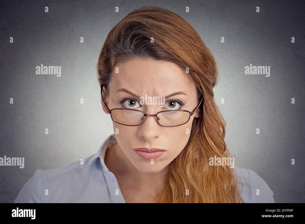 Skepsis. Wütend mürrisch zweifelhaft Frau Sie Kamera auf graue Wand Hintergrund isoliert betrachten. Menschliche Emotionen Gesichtsausdruck Gefühl Körper negativ Stockfoto