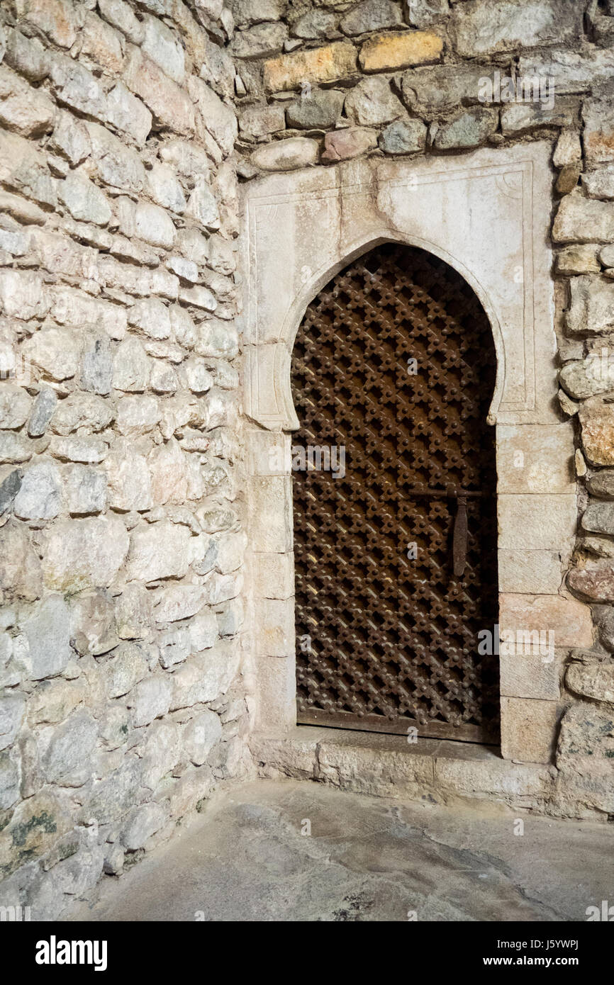 Eine Metallgitter Tür gesetzt in Steinmauern in die arabischen Bäder von Girona, Spanien. Stockfoto