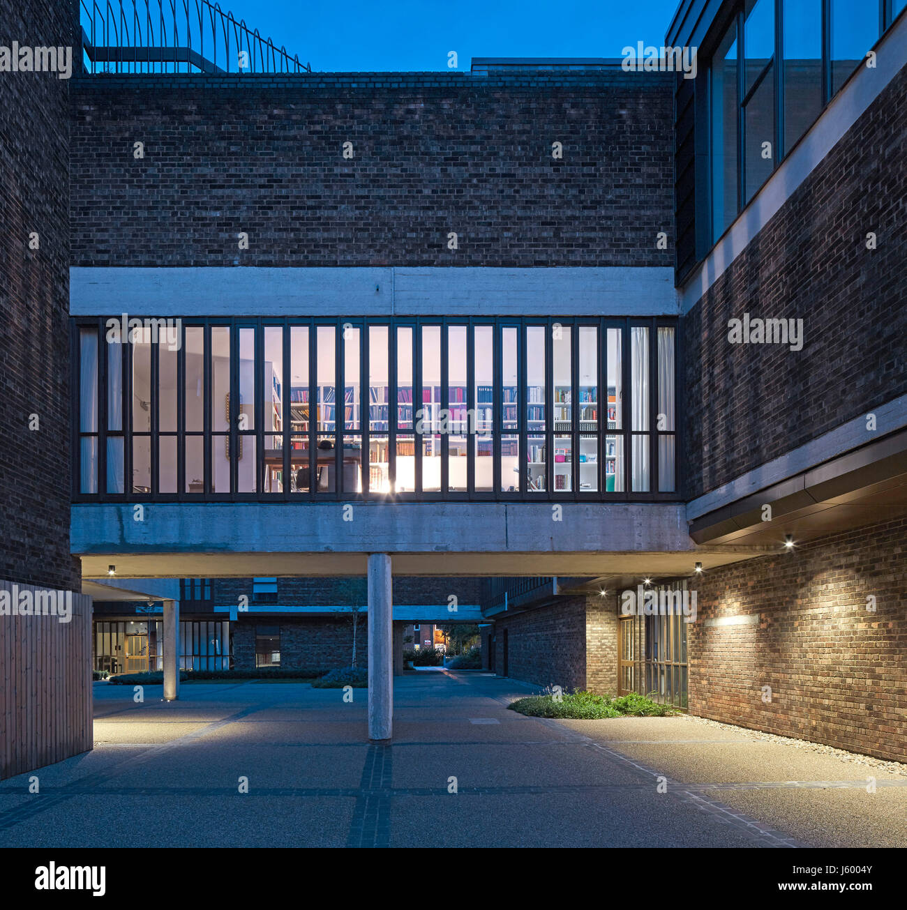 Außenansicht im Innenhof in der Abenddämmerung. Baylis Old School, London, Vereinigtes Königreich. Architekt: Conran und Partner, 1960. Stockfoto