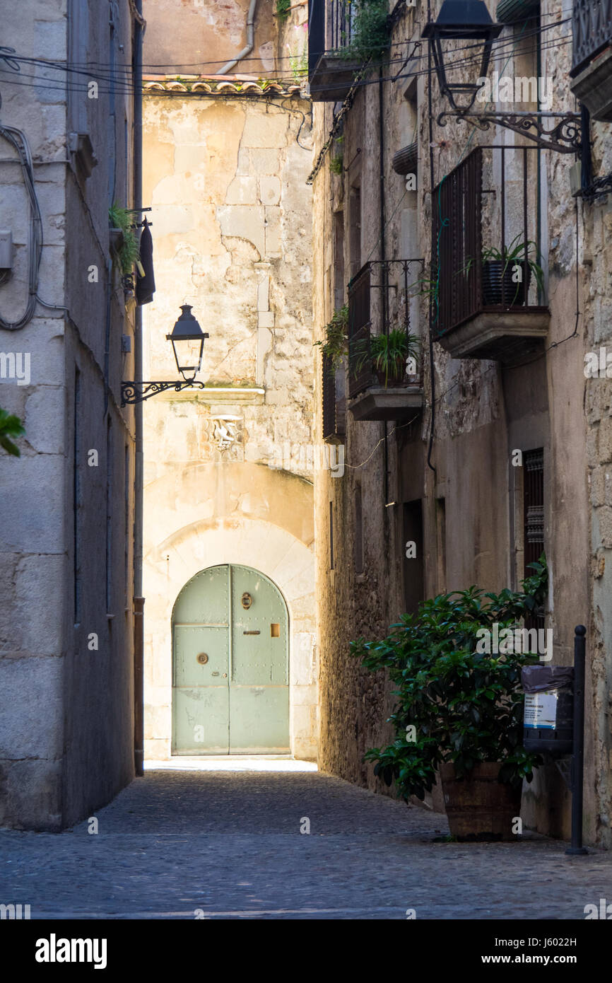 Eine bemalte Metall Bogen Dor am Ende derart schmale Gasse in der Altstadt von Girona, Spanien. Stockfoto Eine bemalte Metall Bogen Dor am Ende derart schmale Gasse in der Altstadt von Girona, Spanien. Stockfoto