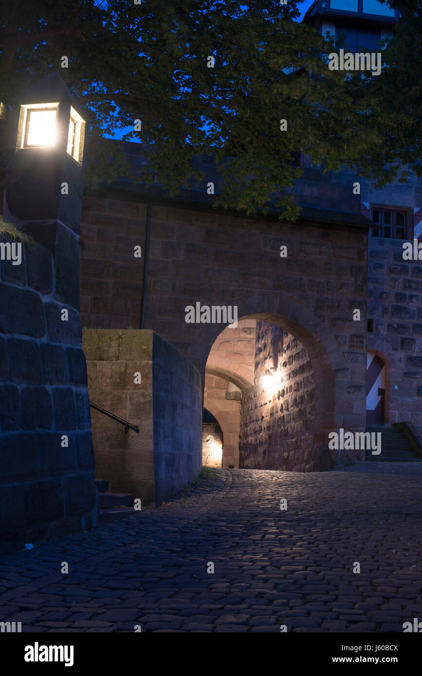 Beleuchtete mittelalterliche Festungsmauern der Nürnberger Burg am frühen Morgen. Nürnberg, Bayern, Deutschland. Stockfoto