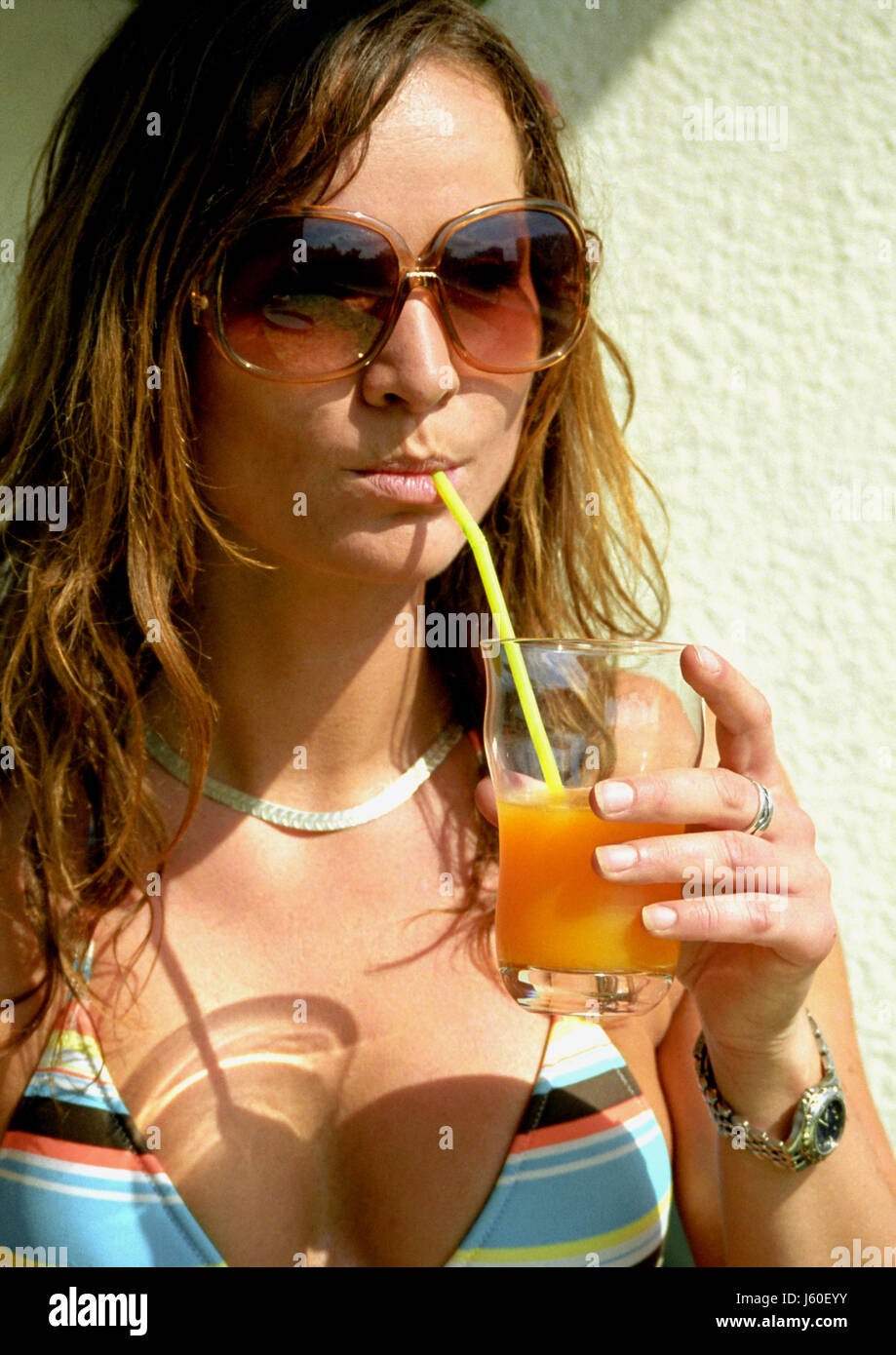 Frau trinken trinken Lätzchen Sommer sommerlich aktualisieren Stroh Sonnenbrille Sonnenbrille Stockfoto