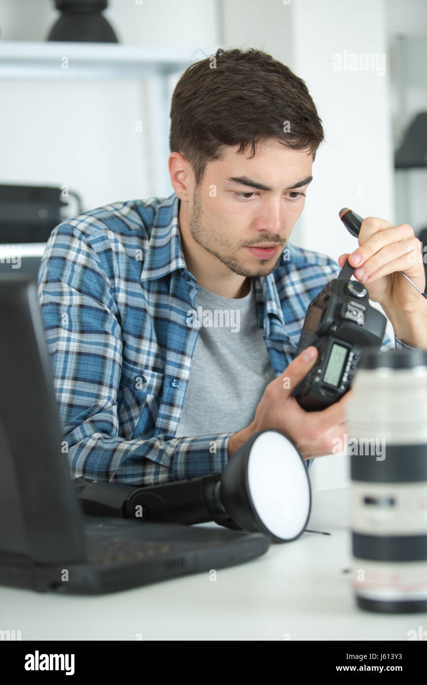 Junger Mann repariert Kamera Stockfoto