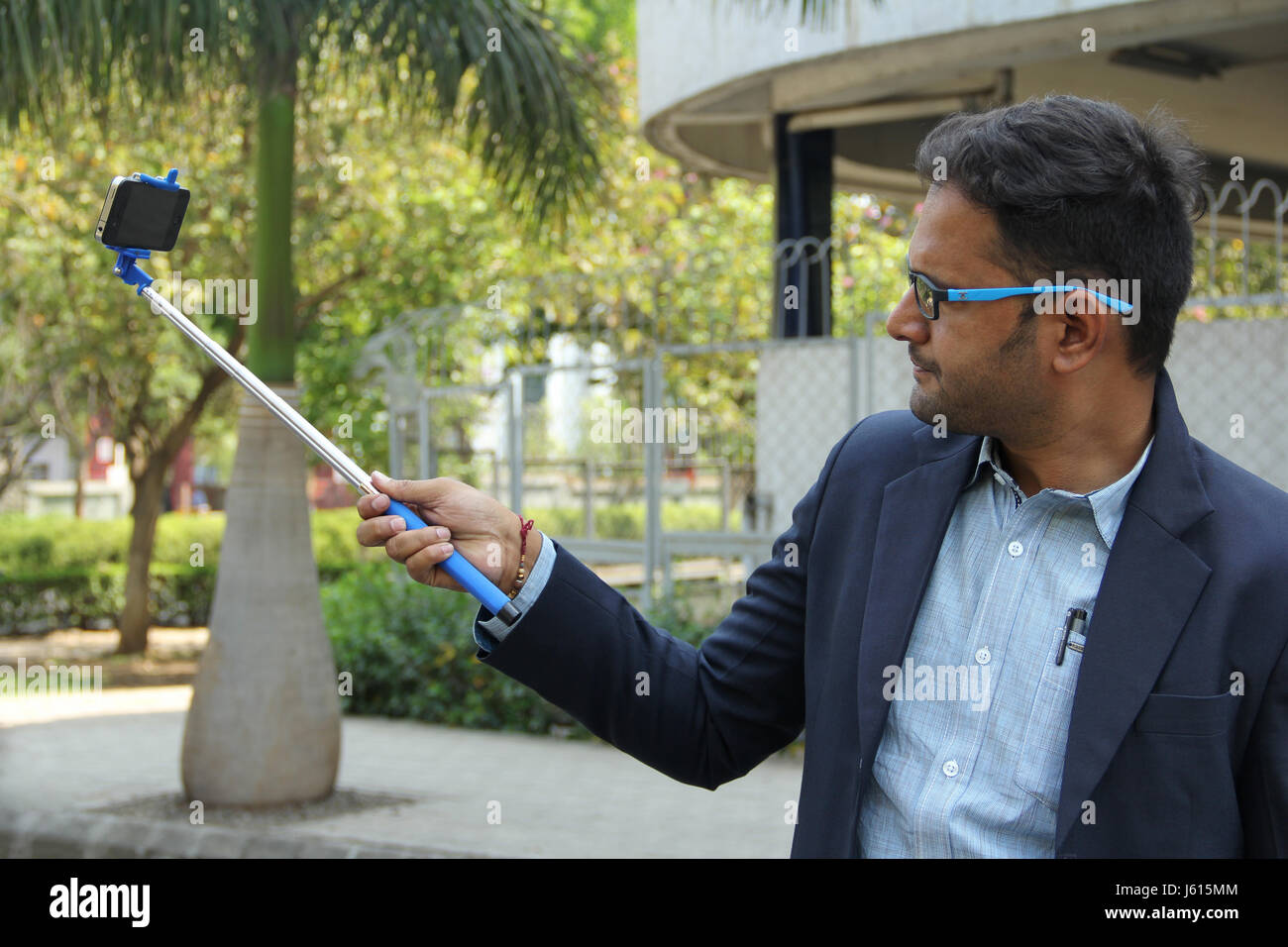 Junge indische Unternehmen Mann im Anzug nehmen Selfie mit Selfie stick Stockfoto