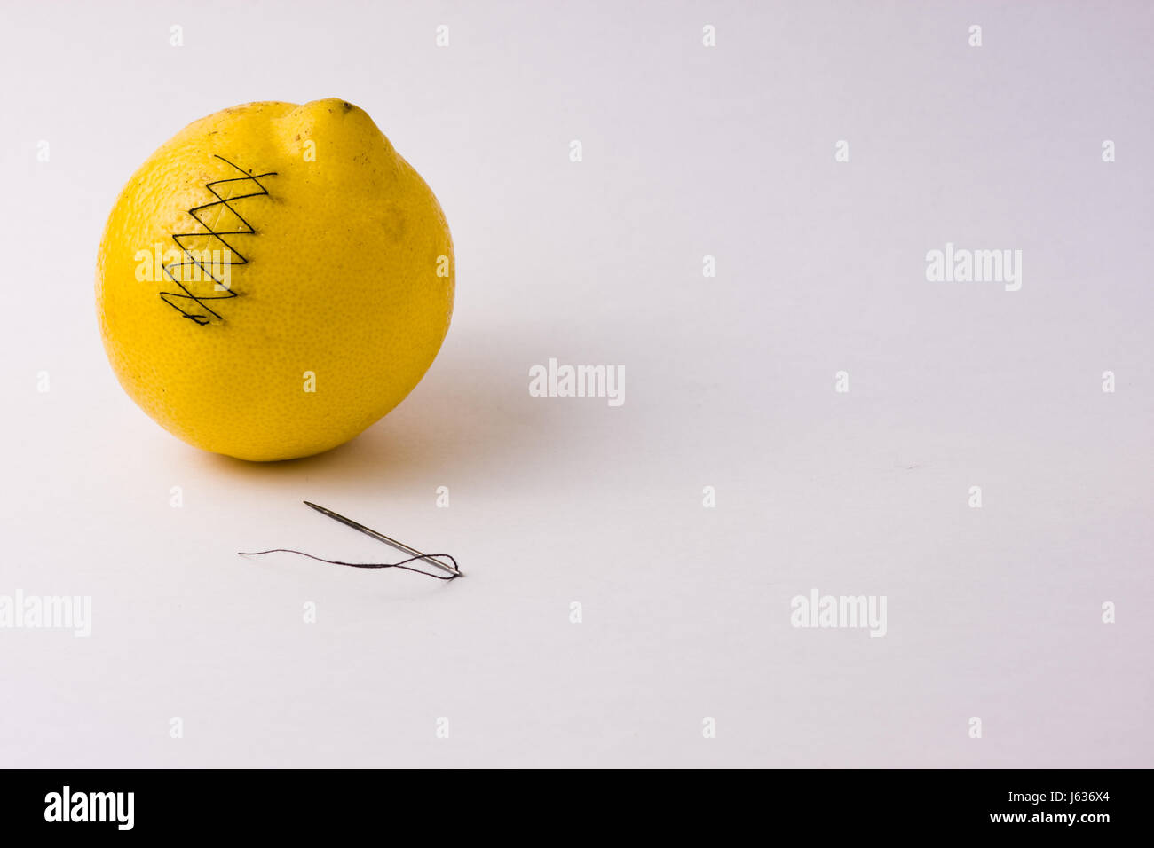 Obst Verletzungen Schüssel genäht Zitrone Citron gelb Gesundheit Schmerzen Heilung Nadelfaden gewickelt Stockfoto