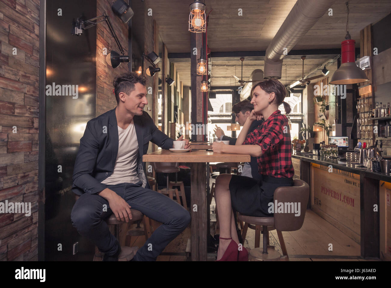 zwei junge Erwachsene Menschen, 20er Jahre, Mann Frau, entspannt, Coffee-Shop im Haus Stockfoto