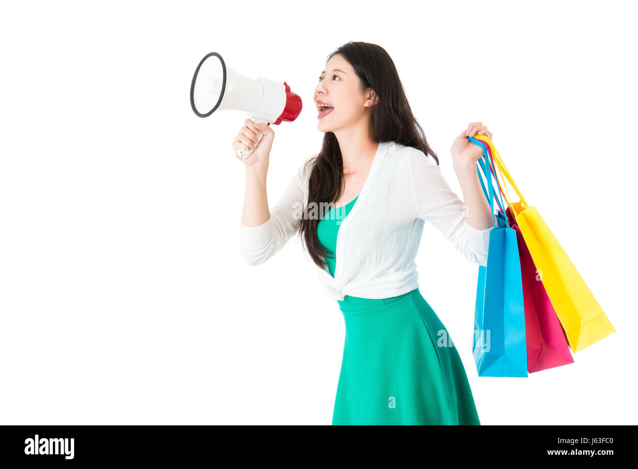 schöne asiatische Frau halten laut Megaphon Anrufs zum Einkaufszentrum Jahrestag Verkauf mit bunten Einkaufstasche. isoliert auf weißem Hintergrund. Stockfoto
