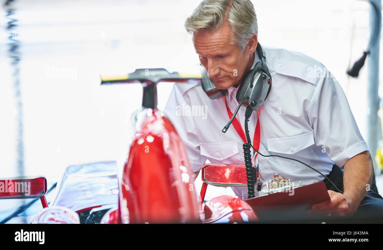 Manager mit Klemmbrett neben Formel 1 Rennwagen Stockfoto