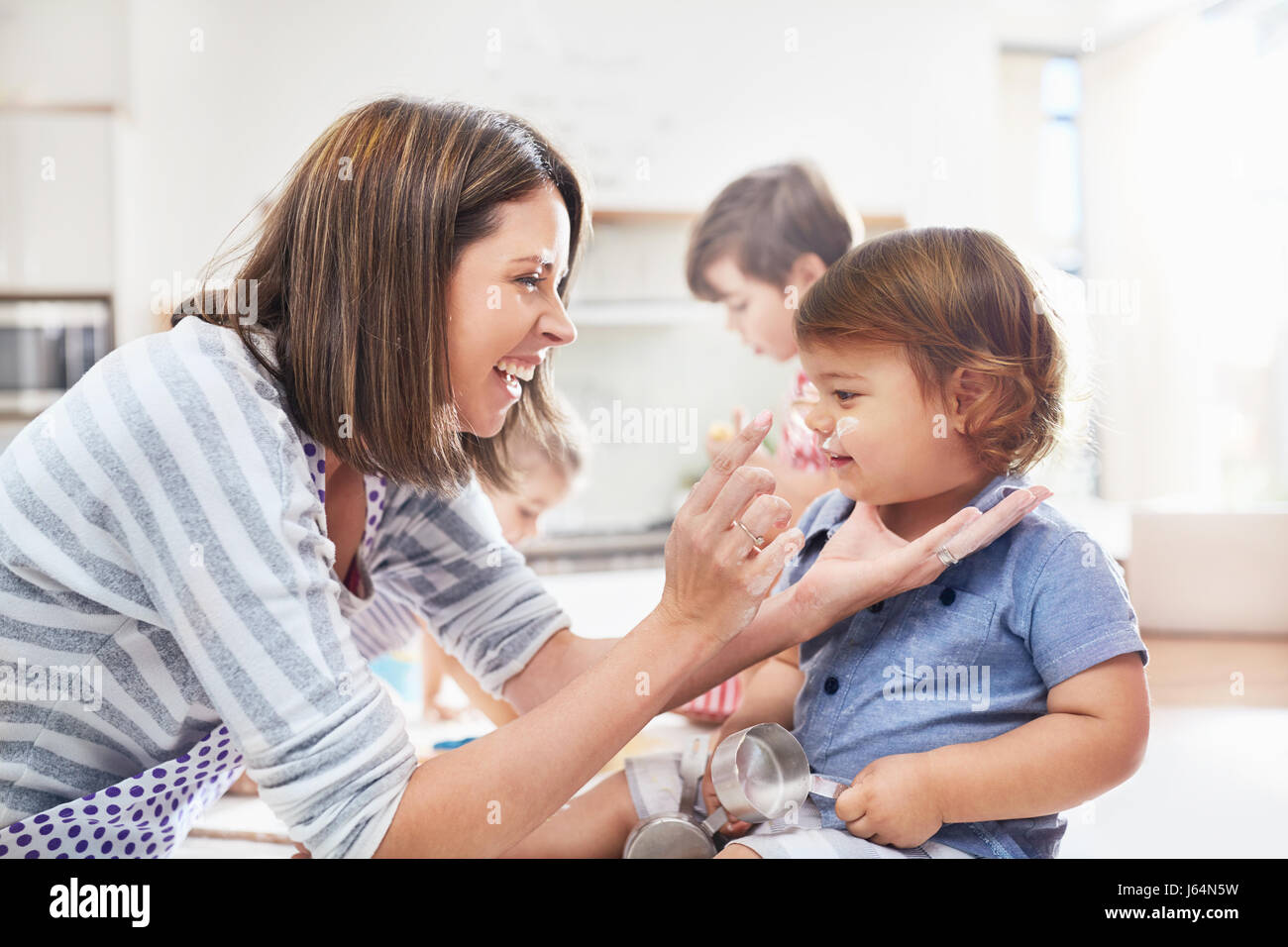 Spielerische Mutter und Sohn mit Mehl auf Nase, Backen in der Küche Stockfoto