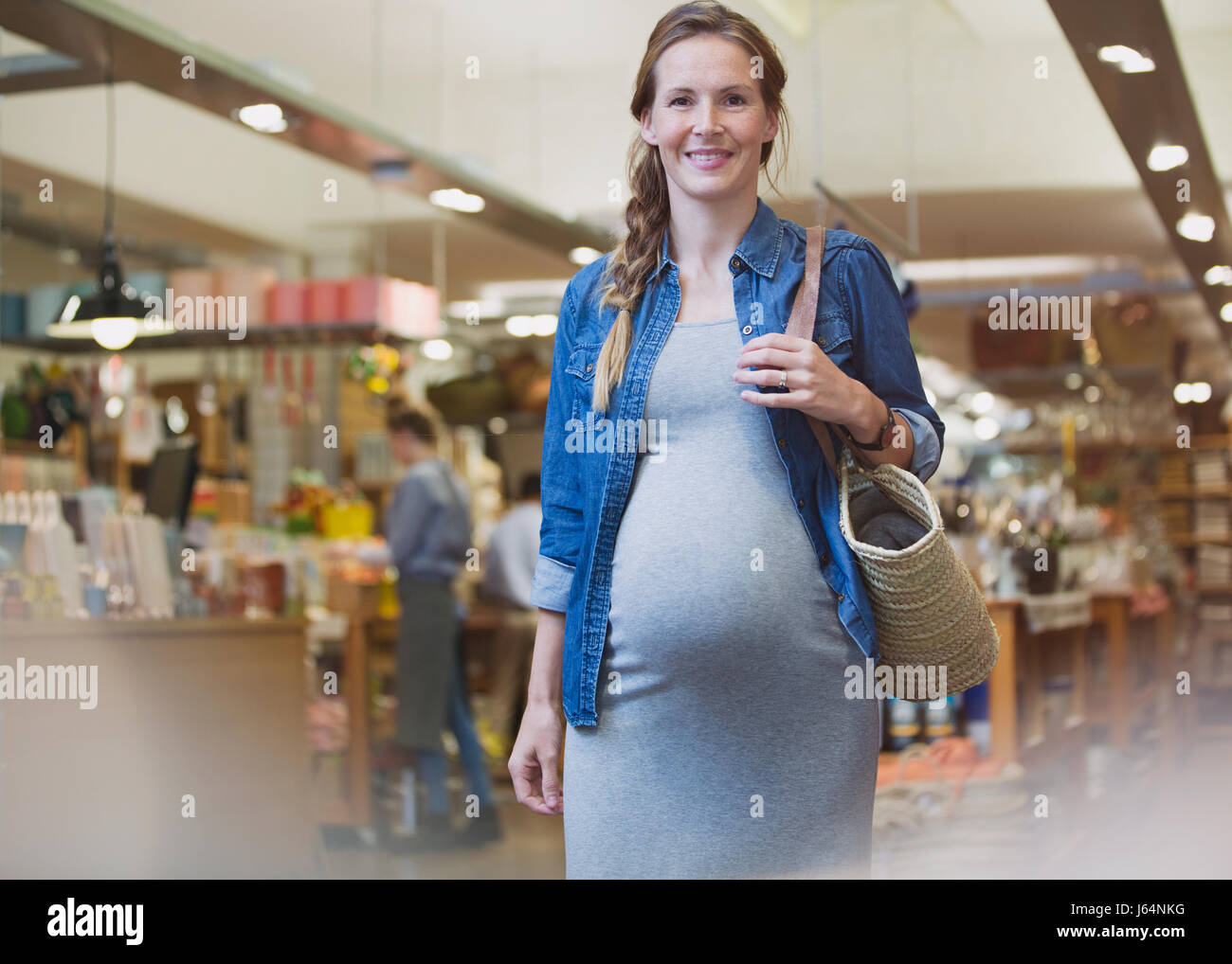 Porträt lächelnd schwangere Frau zu Fuß im shop Stockfoto