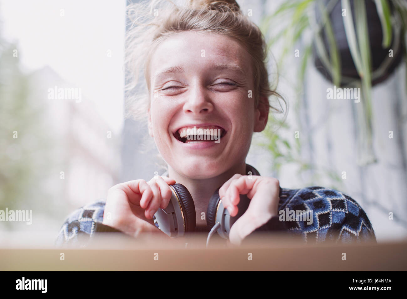 Porträt lachender Junge Frau mit Kopfhörern Stockfoto