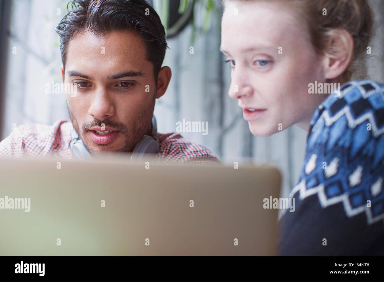 Ernster junger Mann und Frau mit Laptop im café Stockfoto