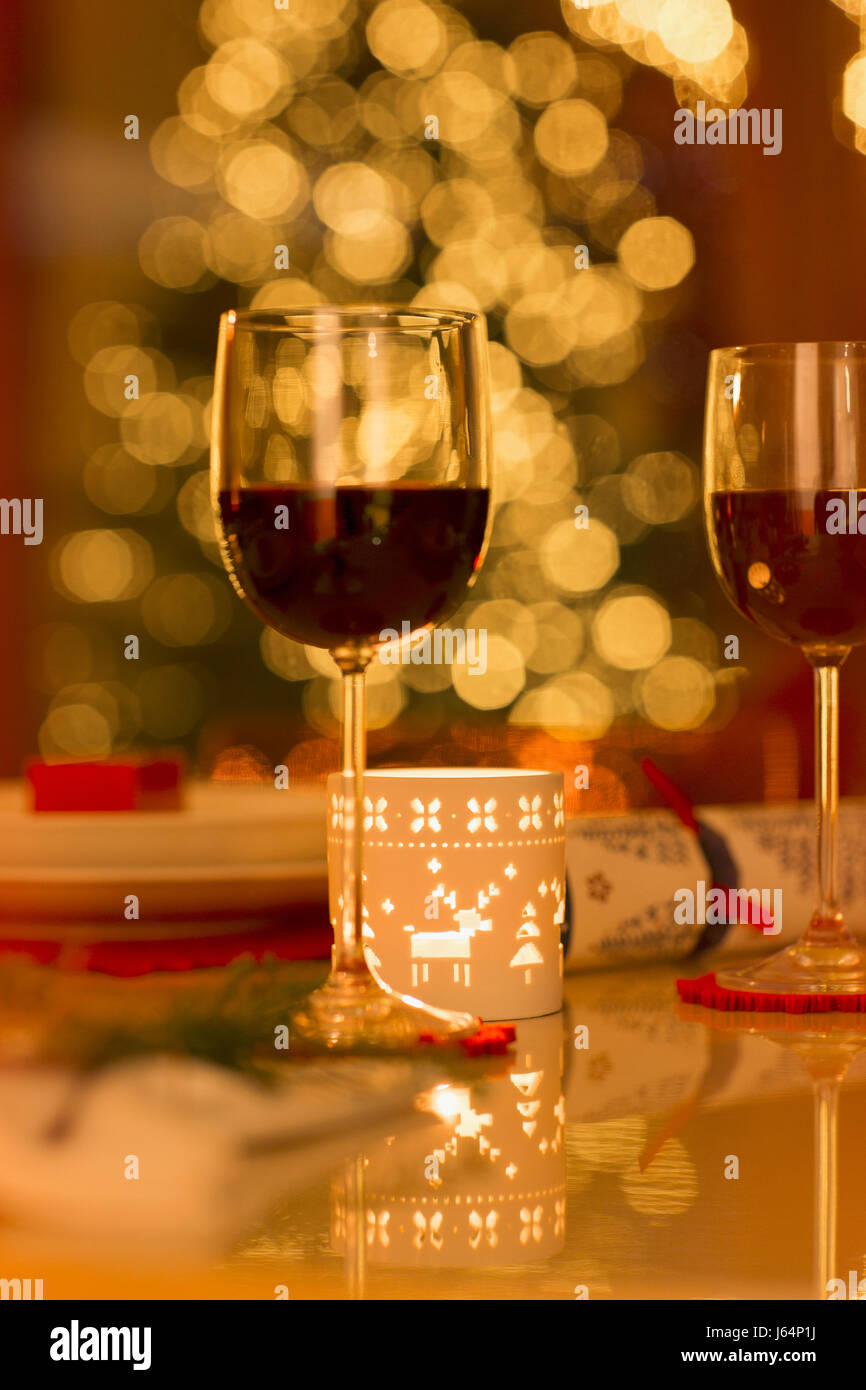 Rotwein und Weihnachtskerze auf Esstisch Stockfoto