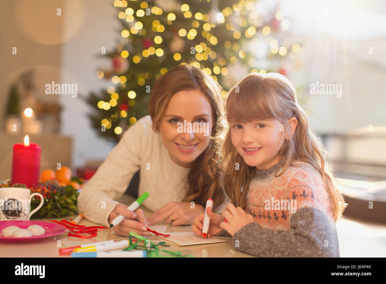 Porträt, Lächeln, Mutter und Tochter Färbung mit Markern in Weihnachten Wohnzimmer Stockfoto