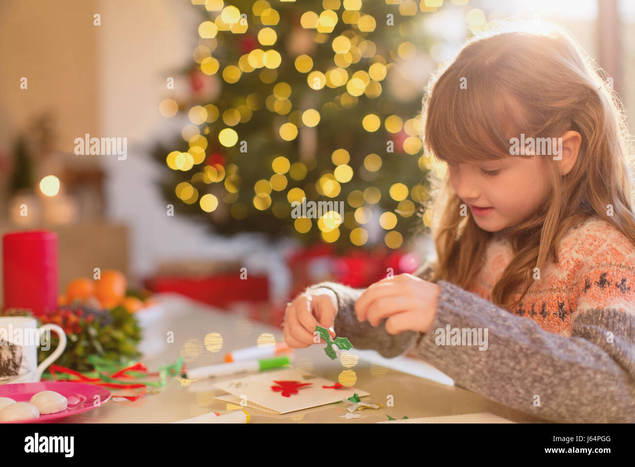 Mädchen, Weihnachtsschmuck am Tisch Stockfoto